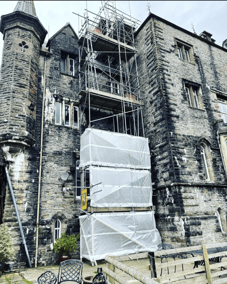 a building with scaffolding and a stone building